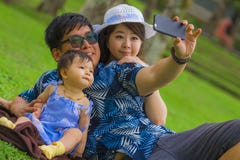 Young Happy Loving Asian Japanese Family With Parents And Sweet Baby Daughter At City Park Together With Father Taking Selfie Pic Royalty Free Stock Photo Young Happy Loving Asian Japanese Family With Parents And Sweet Baby Daughter At City Park Together With Father Taking Selfie Pic Royalty Free Stock Photo