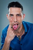 Young Happy Man Sticking Out Tongue. Over a Grey Background Stock Image Young Happy Man Sticking Out Tongue. Over a Grey Background Stock Image