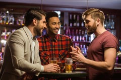 Young happy men drinking beer and talking in cafe royalty free stock image Young happy men drinking beer and talking in cafe royalty free stock image