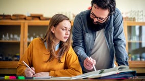 Young hispanic teacher helping his student in chemistry class. Education, Tutoring. royalty free stock image Young hispanic teacher helping his student in chemistry class. Education, Tutoring. royalty free stock image