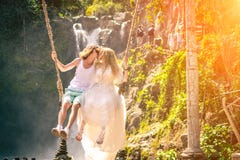 Young Honeymoon Couple Swings In The Jungle Near The Lake, Bali Island, Indonesia. Stock Photos Young Honeymoon Couple Swings In The Jungle Near The Lake, Bali Island, Indonesia. Stock Photos