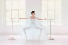 Young and incredibly beautiful ballerina is posing and dancing in a white studio royalty free stock photography Young and incredibly beautiful ballerina is posing and dancing in a white studio royalty free stock photography
