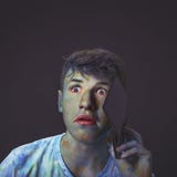 young and interesting guy shrouded in multicolored colors talking on his mobile phone with a surprised expression, a black royalty free stock photo young and interesting guy shrouded in multicolored colors talking on his mobile phone with a surprised expression, a black royalty free stock photo