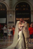 Young interracial couple on the wedding day dancing in the Galleria Vittorio Emanuele in Milan