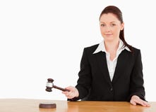 Young judge knocking a gavel smiling at the camera royalty free stock photography Young judge knocking a gavel smiling at the camera royalty free stock photography