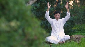 Young latin man sitting in the park and meditating