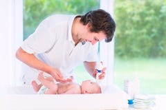 Young loving father changing diaper of newborn son royalty free stock photography Young loving father changing diaper of newborn son royalty free stock photography
