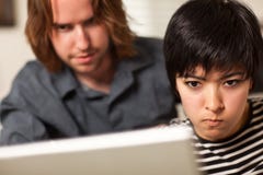 Young Man And Diligent Woman Using Laptop Together Stock Images