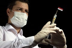 Young man as a doctor gives a medical injection to Egyptian flag royalty free stock photography Young man as a doctor gives a medical injection to Egyptian flag royalty free stock photography