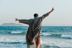 Young man in a bathrobe on the beach royalty free stock photography Young man in a bathrobe on the beach royalty free stock photography