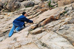 Young Man Climbing Treacherous Mountain Cliff Royalty Free Stock Photography Young Man Climbing Treacherous Mountain Cliff Royalty Free Stock Photography