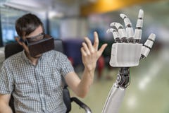 Young man is controlling robotic hand with virtual reality headset Stock Photos Young man is controlling robotic hand with virtual reality headset Stock Photos