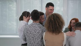 man falls on his back in arms of his colleagues while taking step of trust during group therapy session