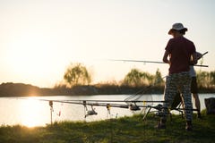 Young man fishing at pond and enjoying hobby stock photos Young man fishing at pond and enjoying hobby stock photos