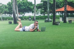Young man in the green tropical park working online with laptop. Freelancer man on Bali island concept. stock image Young man in the green tropical park working online with laptop. Freelancer man on Bali island concept. stock image