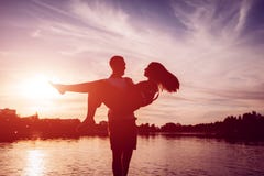 Young man holding woman on summer river bank. Couple having fun at sunset. Guys chilling royalty free stock photos Young man holding woman on summer river bank. Couple having fun at sunset. Guys chilling royalty free stock photos