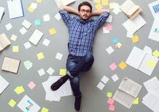 Young man isolated on grey background with papers and notes relaxed looking camera royalty free stock photos Young man isolated on grey background with papers and notes relaxed looking camera royalty free stock photos