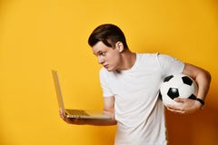 Young man with laptop and a soccer ball royalty free stock photography Young man with laptop and a soccer ball royalty free stock photography