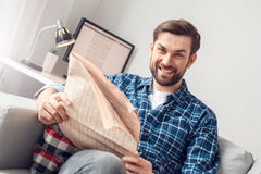 Young man leisure at home sitting holding newspaper cheerful royalty free stock image Young man leisure at home sitting holding newspaper cheerful royalty free stock image