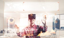 Young man in modern office interior experiencing virtual reality Stock Image Young man in modern office interior experiencing virtual reality Stock Image
