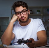 Young man playing games long hours late in the office royalty free stock images Young man playing games long hours late in the office royalty free stock images