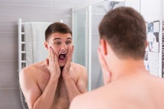 Young Man Put Some Aftershave Lotion On A Face By Two Hands And Stock Photo