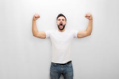 Young man screaming and yelling while posing. He is strong. Guy shows his muscles. Isolated on white background. stock image Young man screaming and yelling while posing. He is strong. Guy shows his muscles. Isolated on white background. stock image