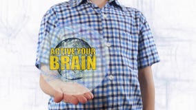 Young man shows a hologram of the planet Earth and text Active your brain royalty free stock image Young man shows a hologram of the planet Earth and text Active your brain royalty free stock image