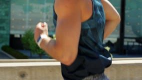 Young man with smart watch running outdoors