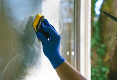 Young man is using a rag and squeegee while cleaning windows. royalty free stock photo Young man is using a rag and squeegee while cleaning windows. royalty free stock photo
