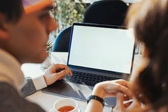 Young man and woman working in front of the laptop with blank white screen royalty free stock photography Young man and woman working in front of the laptop with blank white screen royalty free stock photography