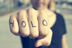 Young man with the word yolo, for you only live once, tattooed i