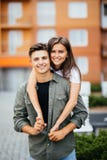 Young man giving girlfirend piggyback ride in city street stock photos Young man giving girlfirend piggyback ride in city street stock photos