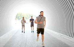 Young men or male friends running in tunnel