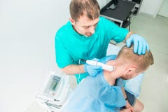 Young man at the physiotherapy receiving laser therapy massage. A chiropractor treats patient`s cervical spine in medical office. royalty free stock image Young man at the physiotherapy receiving laser therapy massage. A chiropractor treats patient`s cervical spine in medical office. royalty free stock image