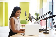 Young mixed race woman recording a podcast in a studio stock photography Young mixed race woman recording a podcast in a studio stock photography