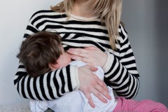 Young Mother Breastfeeding Toddler Boy In Striped Sweater Stock Photography
