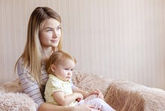 Young mother and her daughter child in armchair stock photo Young mother and her daughter child in armchair stock photo