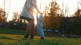 Young mother and her little baby teaching how to walk in autumn park. royalty free stock images Young mother and her little baby teaching how to walk in autumn park. royalty free stock images