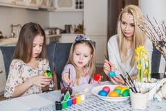 Young mother and her two daughters painting Easter eggs stock image Young mother and her two daughters painting Easter eggs stock image
