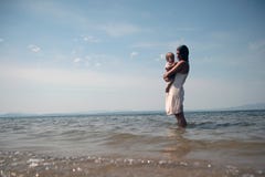 A young mother holds a child in her arms standing in the sea. royalty free stock image A young mother holds a child in her arms standing in the sea. royalty free stock image