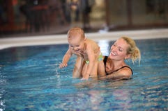 Young mother and little son having fun in a swimming pool royalty free stock photo Young mother and little son having fun in a swimming pool royalty free stock photo