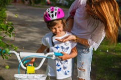 Young mother teaching her daughter how to ride a bicycle in the park. royalty free stock image Young mother teaching her daughter how to ride a bicycle in the park. royalty free stock image