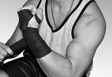 Young muscular fighter wrapping wrists for MMA stock image Young muscular fighter wrapping wrists for MMA stock image