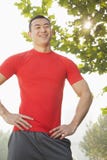 Young muscular man in red shirt standing and smiling, outdoors in a park in Beijing Royalty Free Stock Image Young muscular man in red shirt standing and smiling, outdoors in a park in Beijing Royalty Free Stock Image
