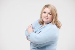 Young obese woman in casual blue clothes on a white background in the studio. Bodypositive. stock photos Young obese woman in casual blue clothes on a white background in the studio. Bodypositive. stock photos