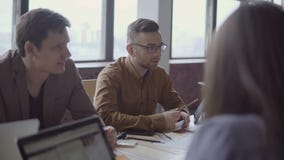 Young and perspective mixed race team discussing new project. Creative group of people working on start-up idea. stock video footage Young and perspective mixed race team discussing new project. Creative group of people working on start-up idea. stock video footage