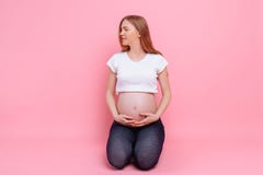 Young pregnant girl hugging her belly with her hands stock photography Young pregnant girl hugging her belly with her hands stock photography