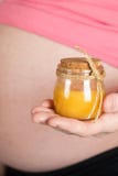 Young pregnant woman keeps glass bottle of natural honey royalty free stock image Young pregnant woman keeps glass bottle of natural honey royalty free stock image