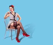 Young Pretty Smiling Woman Sitting On A Chair. Pinup Style Stock Photo
